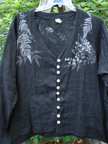 Barclay Linen Tiny Button Dip Side Cardigan Fern Shadow Black Size 0 features a deep V-neck, shell buttons, three-quarter sleeves, and a vented hem, showcasing a white leaf pattern on black.