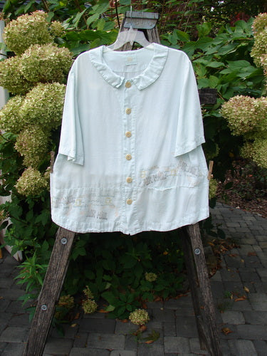 2000 Tencel Camp Shirt Airmail Shark Size 0 displayed outdoors on a wooden stand, featuring a ruffled collar, oversized buttons, and a front pocket, showcasing BlueFishFinder's vintage, expressive style.