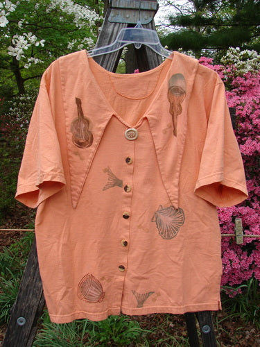 Vintage 1994 Compass Top featuring beach, shells, and music motifs on a peach shirt with guitar details. From the Transitions Summer Collection in Reef, size 2. Exaggerated collar, original vintage buttons, side vents. Length: 30.