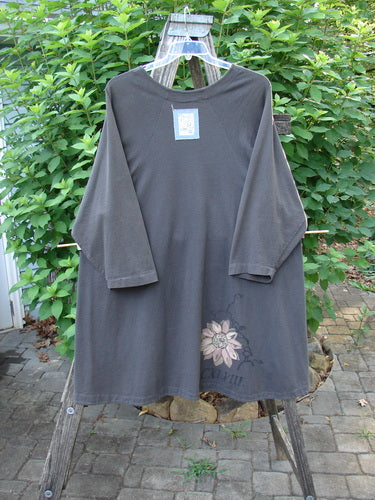 1998 Botanicals Bell Flower Top CXLVIII Raven Size 2 displayed on a clothes rack, featuring a belled A-line shape, upward scooped front hem, and Blue Fish signature patch, showcasing vintage Blue Fish Clothing style.