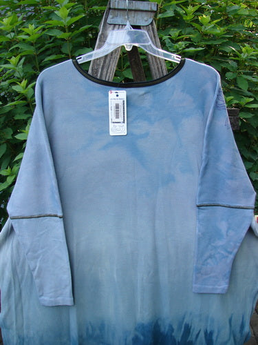 Barclay NWT Thermal Contrast Revival Top Love Dove Blue Skies OSFA displayed on a wooden swing, showcasing its ribbed neckline, tapering sleeves, and unique A-line shape with Love Dove theme accents.