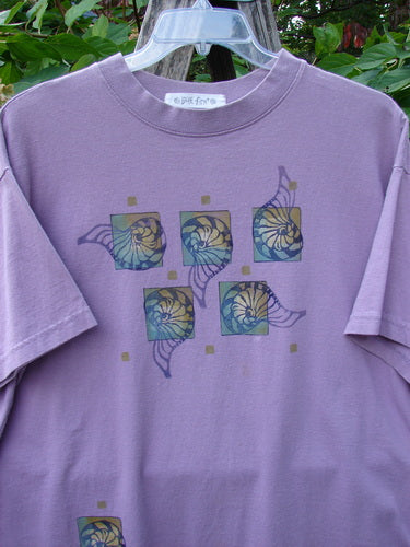 1997 Short Sleeved Tee Five Shell Jasmine Size 1 in lavender-purple with decorative panels of stylized shell motifs. Features a thicker ribbed neckline and boxier shape, showcasing vintage Blue Fish Clothing style.