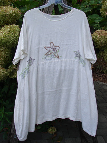 The 1997 Urchin Dress Sealife Froth Size 2 features starfish motifs on a loose-fitting white tunic, showcasing the vintage Blue Fish Clothing style with its artistic seashore theme.