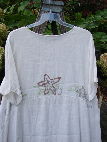1997 Urchin Dress Sealife Froth Size 2 features elbow-length sleeves and starfish motifs on white linen, showcasing a scooped neckline and paneled hem, embodying BlueFishFinder's vintage creative spirit.