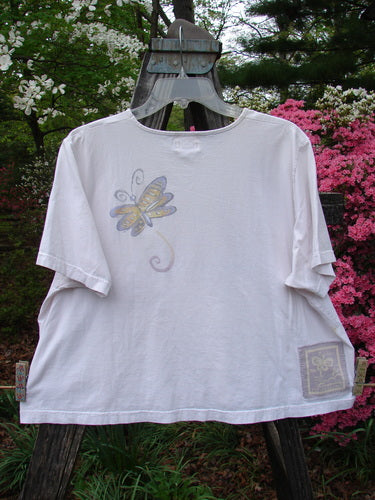 1999 Light Weight Short Sleeved Crop Tee Butterfly Orchid Size 2, featuring a butterfly design on organic cotton, short sleeves, and a rounded neckline, displayed flat to highlight its unique fabric.