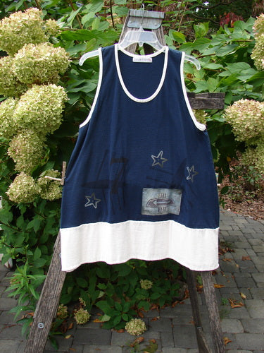1998 8 Ball Tunic Games Crew Blue Size 1 showcased on a wooden ladder outdoors, featuring a navy top with star motifs and off-white bottom band against green foliage and hydrangeas.