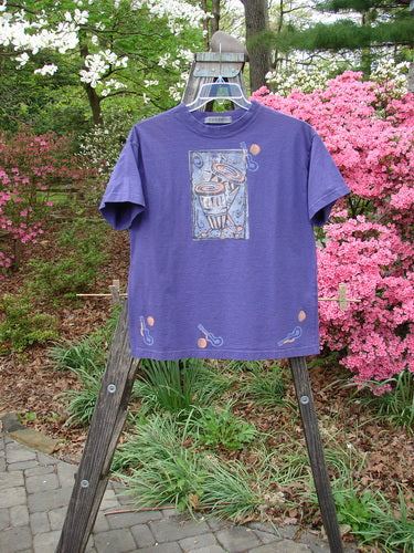 Vintage 1996 Short Sleeved Tee Drum Niagara Size 0 from BlueFishFinder.com: A purple tee with a drum theme, ribbed neckline, drop shoulders, and a boxy shape. In perfect condition, made from organic cotton.