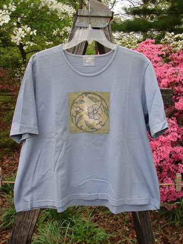 1999 Patched Short Sleeved Crop Tee Floral Medallion Bluestone Size 1, featuring a graphic floral medallion design and a feminine rolled neckline, made from mid-weight organic cotton.