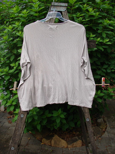 Barclay Cotton Slub Cricket Cap Sleeve Tee Poppy Garden Mist OSFA displayed on a clothes rack, showcasing its seamless shoulder sleeves, rounded hemline, and boxy shape, embodying vintage Blue Fish Clothing's expressive style.