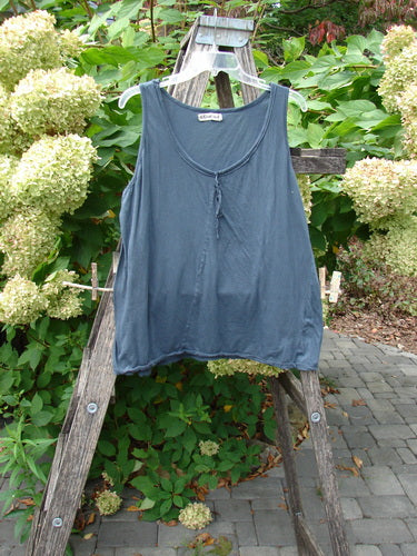 Barclay Batiste Decora Tiny Tank Unpainted Navy Size 2 on a hanger over a wooden ladder, showcasing its A-line shape and front vertical neckline tie against lush hydrangeas.