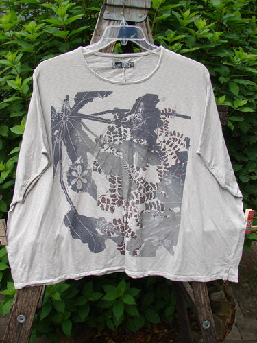 Barclay Cotton Slub Cricket Cap Sleeve Tee Leaf Play Natural OSFA displayed on a swinger, highlighting its cap sleeves, rounded hemline, and seamless shoulder with a leaf graphic design, embodying Bluefishfinder's vintage style.