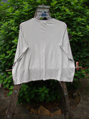 Barclay Cotton Slub Cricket Cap Sleeve Tee Leaf Play Natural OSFA displayed on a wooden ladder, showcasing its seamless cap sleeves, rounded hemline, and boxy shape, reflecting BlueFishFinder's vintage-inspired, creative style.