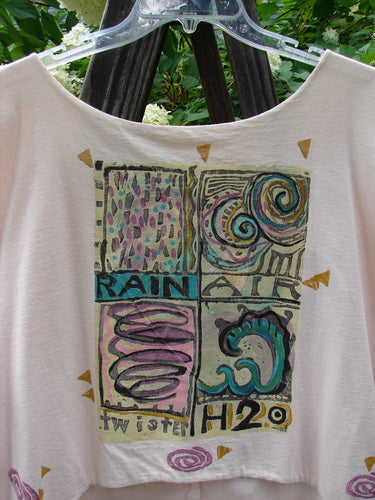 1992 Folk Vest Elements Tea Dye OSFA: A white shirt with a graphic design on it, made from double layered mid-weight cotton. Features include a tuxedo front tail, upward scooped back line, and original vintage buttons. Bust 56, waist 56, front length 29, back length 20 inches.