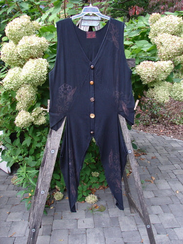 Barclay Calligrapher's Vest Asian Inspiration Black Size 0 displayed on a wooden hanger over a ladder, showcasing its dramatic asymmetrical hem and mismatched buttons, with an artistic, vintage-inspired design.