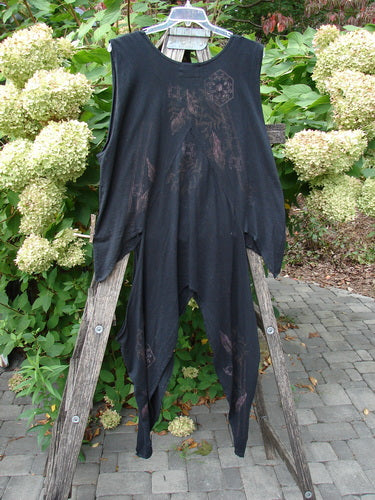 Barclay Calligrapher's Vest Asian Inspiration Black Size 0, featuring a unique asymmetrical hem and faint brownish print, displayed on a wooden ladder with floral and greenery backdrop, showcasing its artistic design.
