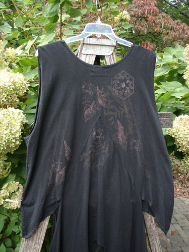 Barclay Calligrapher's Vest Asian Inspiration Black Size 0 draped on a ladder, showcasing its unique asymmetrical hem, deep V-neck, and vintage buttons against a lush outdoor backdrop.