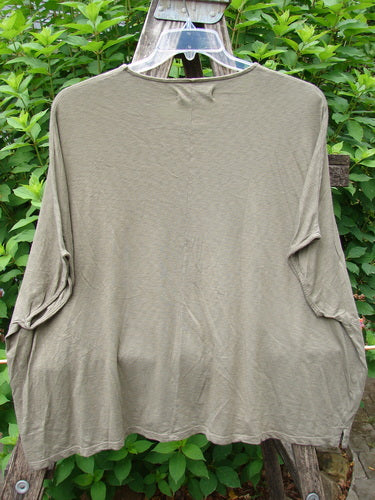 Barclay Cotton Slub Cricket Cap Sleeve Tee Forest Flock Bottlecap OSFA displayed on a clothes rack, showcasing its cool cap sleeves, seamless shoulder, and rounded hemline, embodying vintage Blue Fish Clothing's creative spirit.