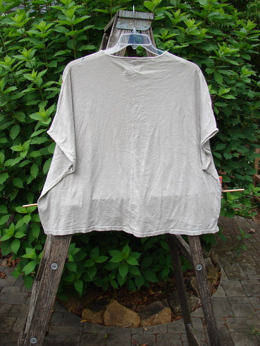 Barclay Cotton Slub Cricket Cap Sleeve Tee Butterfly Flax OSFA displayed outdoors on a swinger, showcasing its seamless shoulder sleeves, cap sleeves, and rounded hemline, reflecting Blue Fish Clothing's vintage, expressive style.