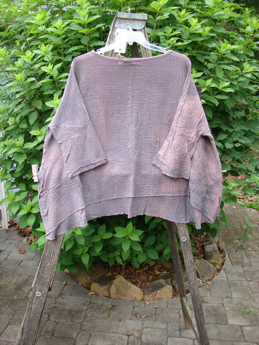 Barclay NWT Crinkle Gauze Top in Mottled Smokey Rose Quartz OSFA on a clothes rack, showcasing its high-low hemline and three-quarter dolman sleeves, embodying Bluefishfinder.com's unique vintage style.