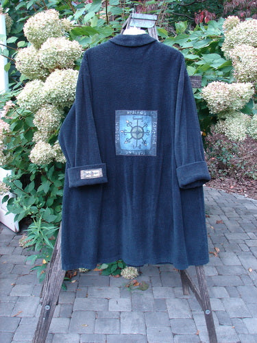 1999 Patched Chenille Angle Pocket Jacket Holiday Black Size 1 draped on a wooden ladder, showcasing its oversized vintage button, large holiday-themed patch, angled pockets, and drop shoulders.