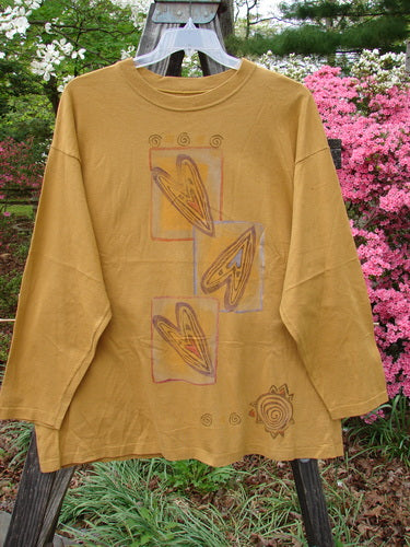 Vintage 1996 Long Sleeved Tee from BlueFishFinder in Old Gold. Features include a dropped shoulder, ribbed neckline, and Falling Heart design. Made of heavy organic cotton jersey. Size 2, Bust 52, Waist 52, Hips 62, Length 29.