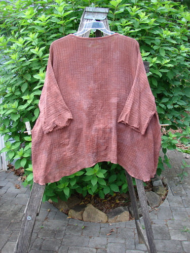 Barclay Crinkle Gauze Top Mottled Monrovian Brick OSFA displayed on a wooden stand, showcasing its high-low hemline, three-quarter dolman sleeves, and soft, textured fabric.
