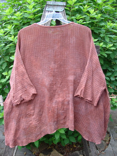 Barclay Crinkle Gauze Top Mottled Monrovian Brick OSFA displayed on a clothesline, showcasing its wide, boxy shape, three-quarter dolman sleeves, and high-low hemline, highlighting its forgiving, soft texture.
