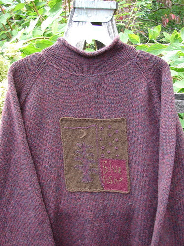 1998 Patched Alpaca Roll Neck Raglan Sweater Wineberry Tweed OSFA features a maroon-purple knit with a turtleneck, felt patch, and ribbed collar, crafted from marled alpaca wool, hanging outdoors.