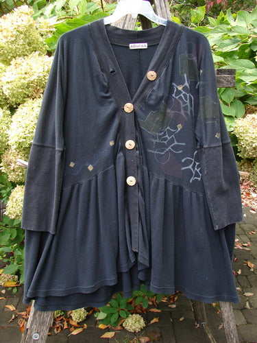 Barclay Thermal Bungalow Jacket Modern Graphics Black OSFA features a flared hem, geometric design, and large wooden buttons, hanging against garden foliage, embodying BlueFishFinder's vintage and expressive style.