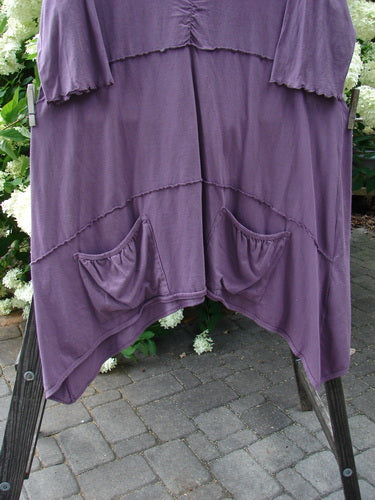 Barclay Gather Front Pocket Dress in Dusty Plum, Size 2. A purple dress with a vertical gather and drop pockets. Made from medium weight organic cotton.