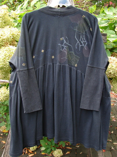 Barclay Thermal Bungalow Jacket Modern Graphics Black OSFA displayed outdoors, featuring a gathered lower half, hip-level pockets, and abstract motifs on a slate-blue background, embodying BlueFishFinder's vintage, creative style.