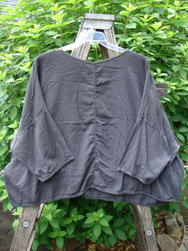 Barclay Twill Atmosphere Overlayer Boxy Top Unpainted Black OSFA displayed on a hanger, showcasing its wide, flowy shape and three-quarter dolman sleeves, crafted from featherweight textured cotton twill.