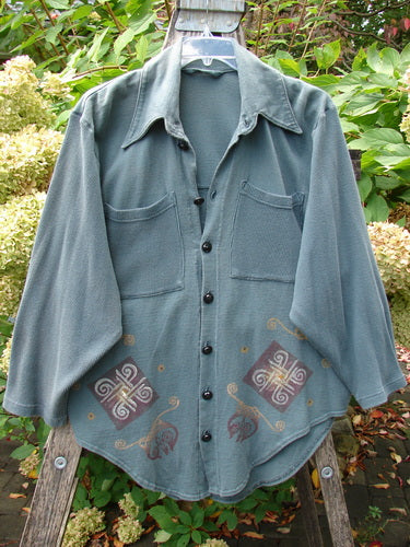 1996 Celtic Filias Jacket Celtic Loch Size 1, featuring a forest-green hue, spread collar, two chest patch pockets, southwestern motifs, and drop shoulders, hanging on a wire hanger outdoors.