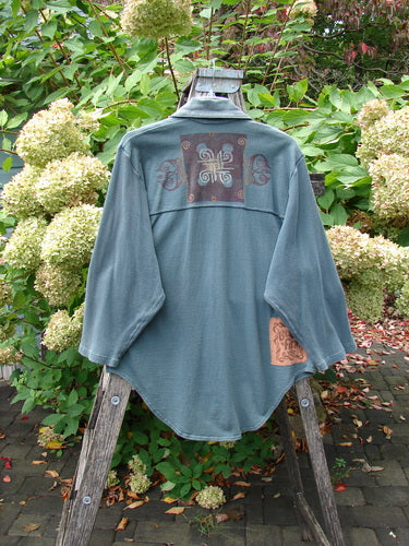 1996 Celtic Filias Jacket Celtic Loch Size 1 displayed on a wooden stepladder in a garden, featuring a distinctive dark patch with embroidery on the back and a smaller contrasting patch near the hem.