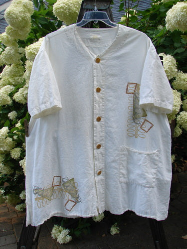 2000 Hemp Viscose Asymmetric Top Space White Size 1: A white shirt with a design on it, buttons, and a flower.