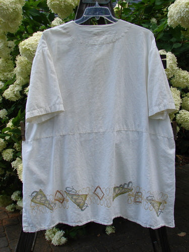 2000 Hemp Viscose Asymmetric Top Space White Size 1: A white shirt with embroidery and a design, featuring a full button front, V-shaped neckline, varying hem, drop pocket, and rear seam.