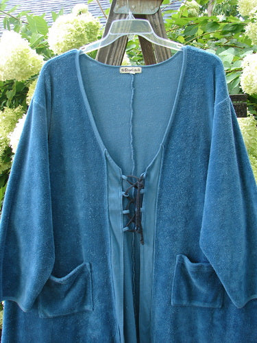 A teal Barclay Chenille Rippie Tie Front Robe Jacket in perfect condition. Features include exterior pockets, A-line shape, varying hemline, vertical cotton paneling, deep V-shaped neckline, and sleeve closures. Bust 62, Waist 66, Hips 70, Sweep 80, Front Length 35, Back Length 40 inches.
