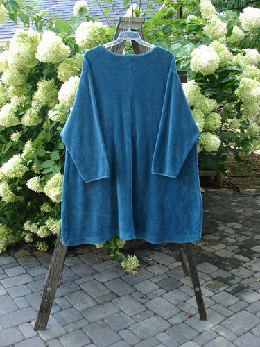 A teal Barclay Chenille Rippie Tie Front Robe Jacket on a clothes rack, featuring a double drop front, A-line shape, and deep V neckline.