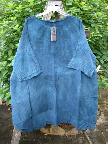 Barclay NWT Crinkle Gauze Ana Tunic Dress in Mottled Teal displayed on a hanger, featuring wide three-quarter sleeves and a varying hemline, showcasing its generous, flowing design.