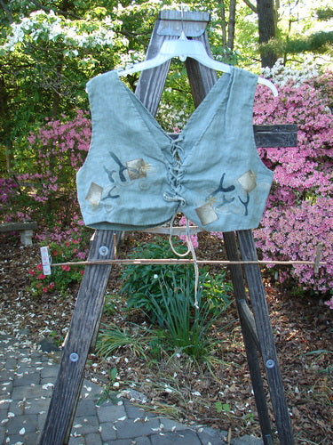 1997 Beachcomber's Vest Undersea Lagoon Size 2 displayed on a wooden ladder, featuring front and back lacings, boxy crop shape, and an undersea theme design, perfect for layering.