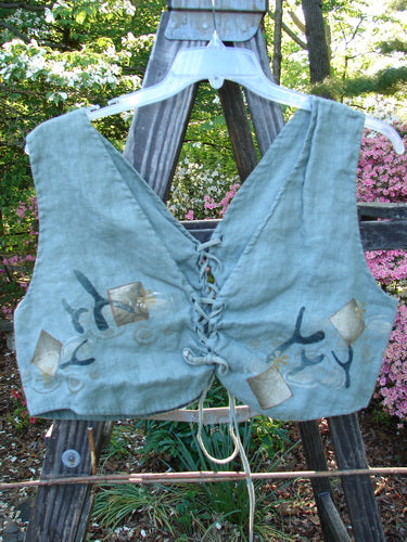 1997 Beachcomber's Vest Undersea Lagoon Size 2; a blue vest on a hanger featuring lace-up front and back, wide boxy crop shape, undersea theme paint, perfect for layering.