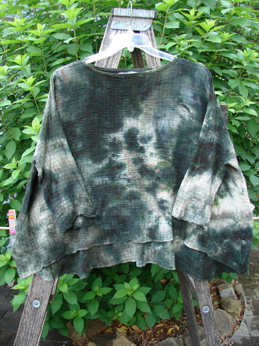 Barclay Crinkle Gauze Crop Top Mottled Forest Black Sky OSFA displayed on a hanger outdoors, showcasing its wide, boxy shape and three-quarter dolman sleeves with a soft, textured finish.