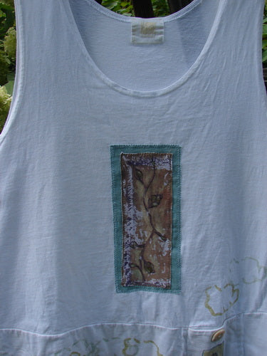 2000 PMU Patched Sun Tank Quiet Vine Cloud White Size 1 features a cropped A-line shape with a double-layered hem, tiny button pocket, and vine-themed patch, showcasing Blue Fish's playful design.