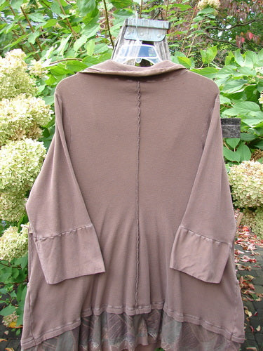 Barclay Thermal Flutter Neck Kangaroo Pocket Top Leaf Mud Size 0 featuring a loose fit, three-quarter sleeves, vertical back seam, ruffled hem, sailor collar, and dual front pockets, hanging outdoors.