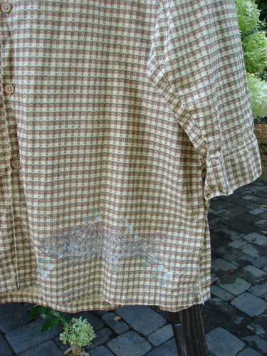 A close-up of a 1996 Tourist Top Fish Border White Pine shirt, featuring a full button front, cuffs and buttons, and soft continuous fish border theme paint. Size 2.