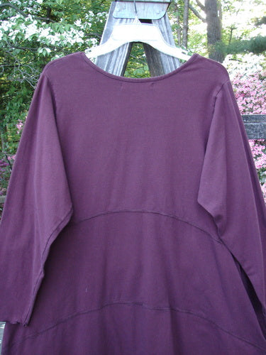 Barclay Cotton Lycra Shape Dress Unpainted Burgundy Size 1 displayed on a wooden hanger, featuring a rounded neckline, long sleeves, and empire waist with a sweeping hemline.