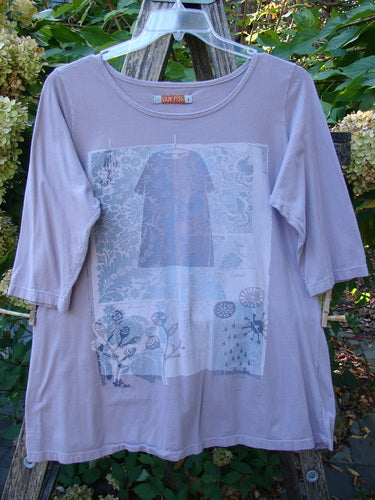 Barclay Three Quarter Sleeved Tee Play Dress Up Lilac Size 1, displayed on a hanger, features a botanical graphic on its front, crafted from organic cotton with elbow-length sleeves and a unique neckline.