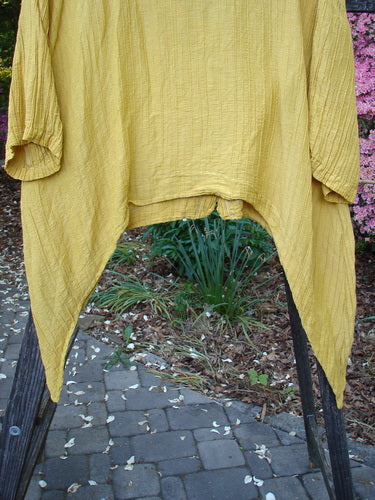 Barclay Silk Rib Dip Side Button Jacket in Golden, Size 1, hanging on a clothesline. Features a deep neckline, dipped sides, varying hemline, and pearly front buttons. Vintage Blue Fish Clothing from BlueFishFinder.com.