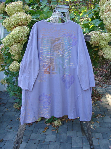 Barclay Art Studio Roo Sweatshirt Rear Rain Garden Lavender OSFA, featuring a rounded neckline, external stitchery, and high-low hem, elegantly displayed on a wooden ladder against a garden backdrop.