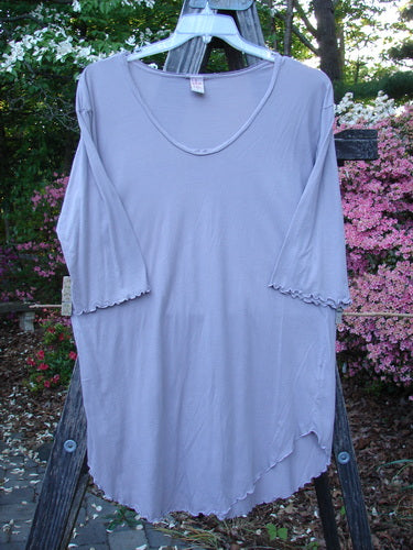 Barclay Batiste Round Bottom Shirt Unpainted Lavender Size 1 displayed on a wooden ladder, showcasing its deep neckline, curly edgings, rounded hemline, and three-quarter length sleeves.